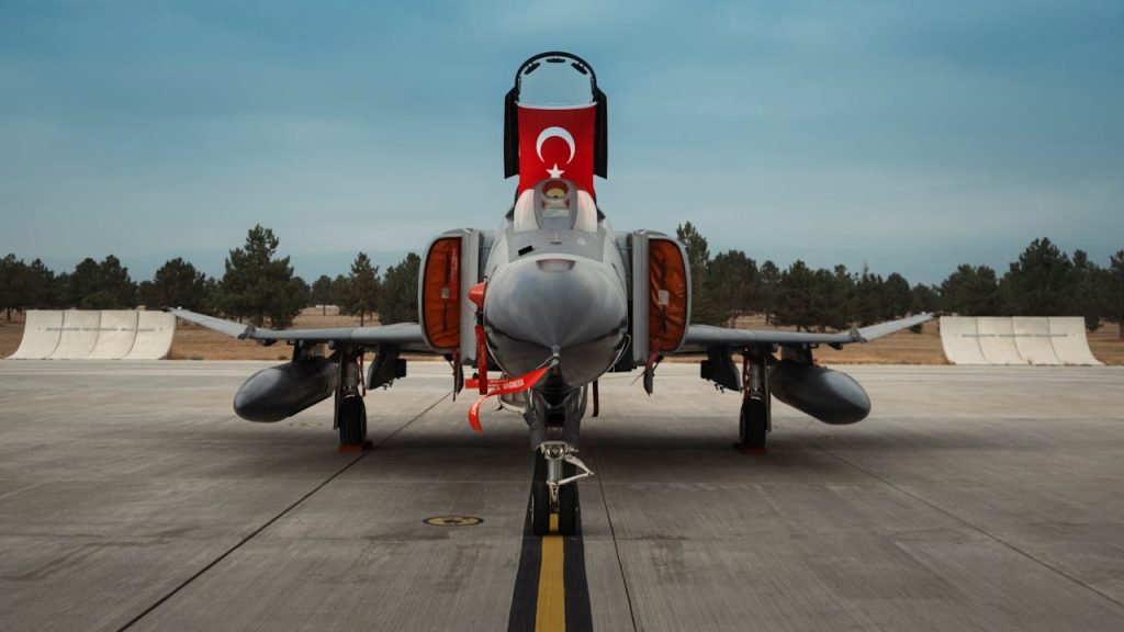 Front view of a Turkish military jet fighter showcasing its national flag on a runway.